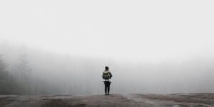 Persona frente a un camino cubierto de niebla como metáfora del miedo disfrazado de prudencia