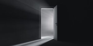 Persona frente a una puerta abierta simbolizando creencias limitantes y libertad interior